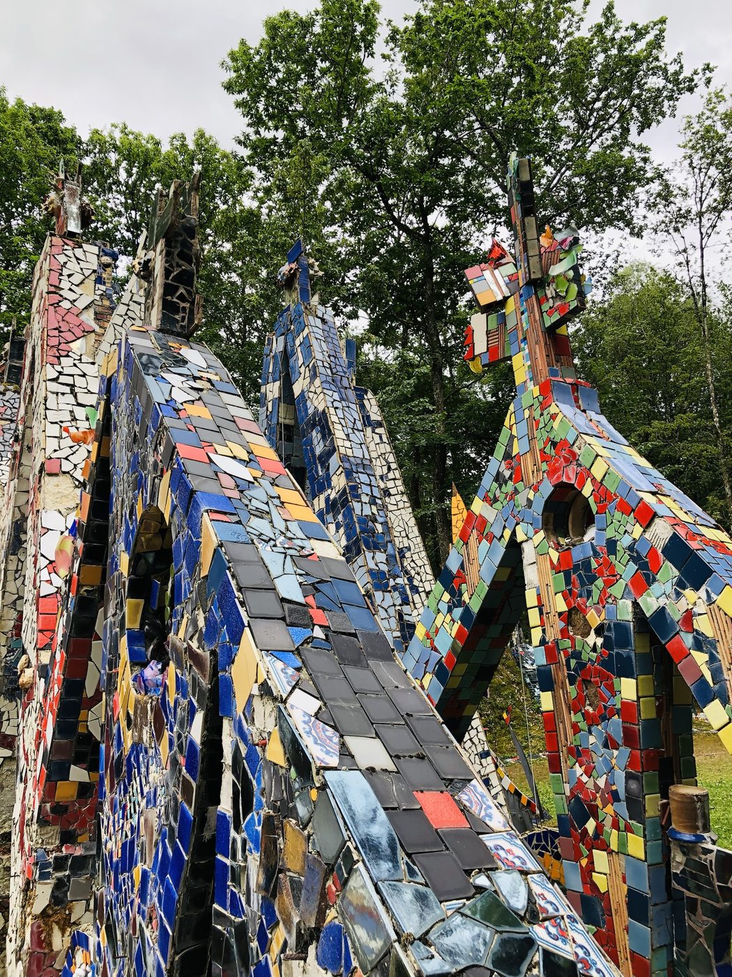Les flèches de mosaïque s'élancent vers le ciel, hérissées de tessons et de goulots de bouteilles.